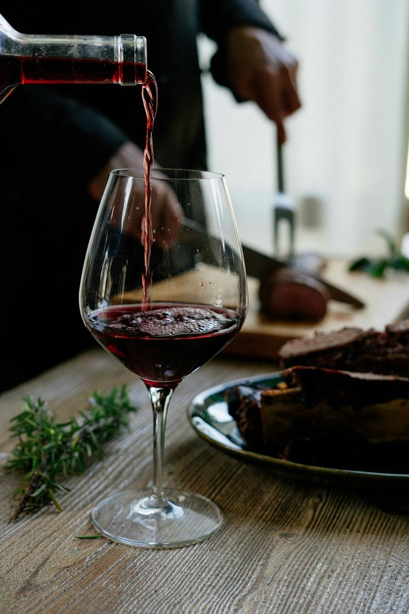 Vino rosso versato in un calice su una tavola apparecchiata